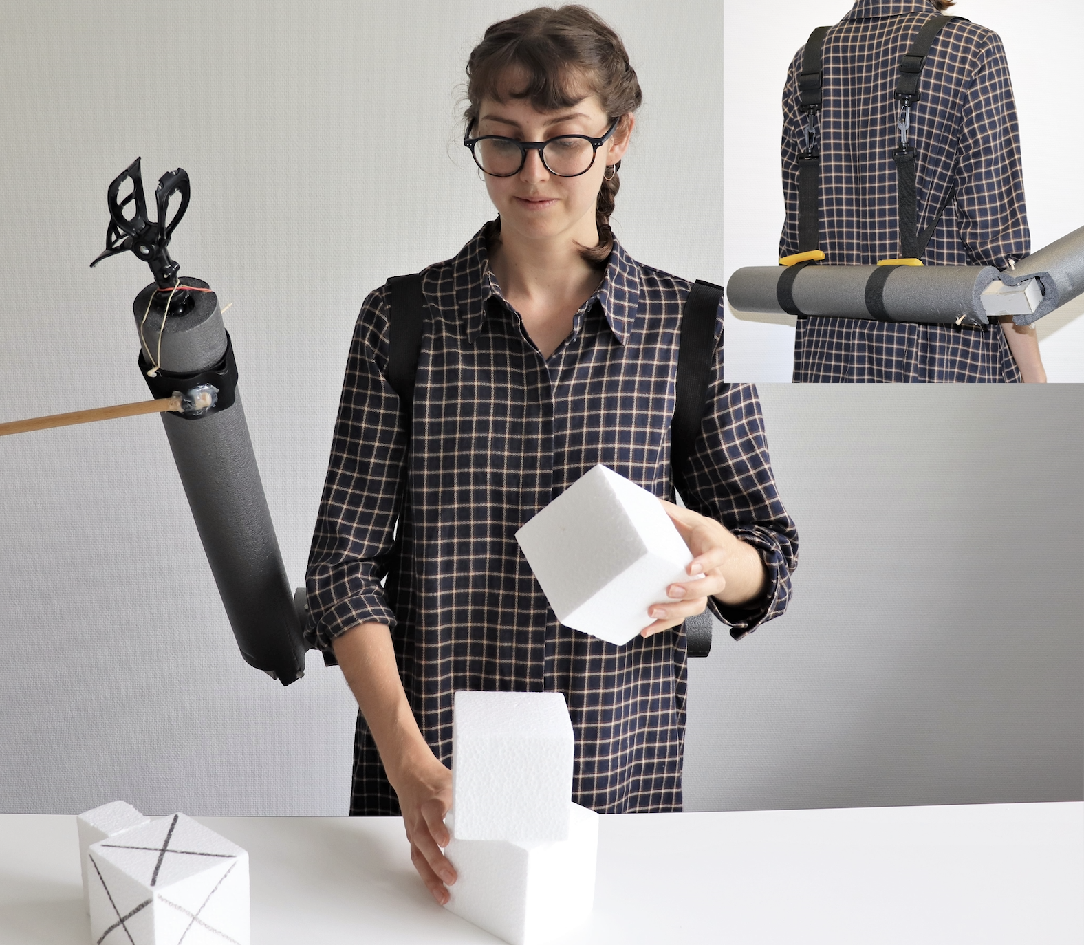 Photo of a women with a non-functional prototype of a third arm.